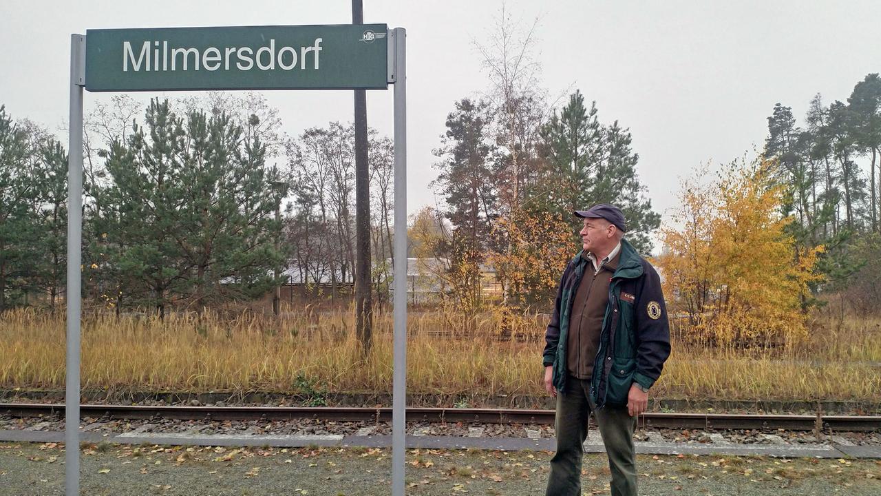 Bürgermeister Christian Arndt vor dem Bahnhofsschild von Milmersdorf