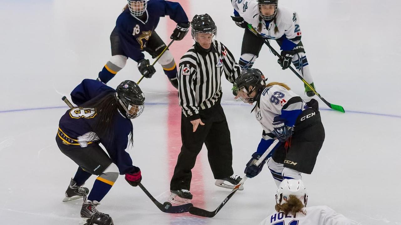Zwei Eishockey-Frauenteams stehen sich zu einem Face-off gegenüber. Zwei Eishockey-Frauenteams stehen sich zu einem Face-off gegenüber.