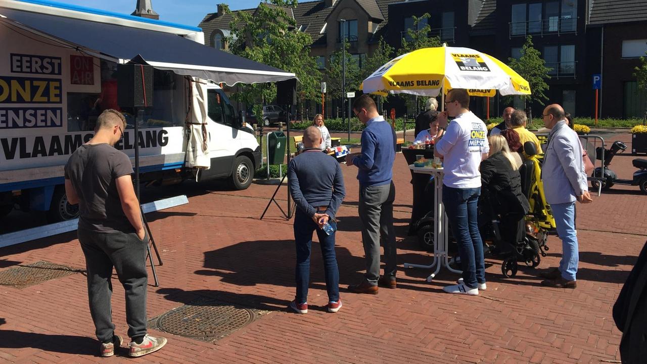 Marktplatz mit Wahl-VW-Bus und Menschen drumherum Marktplatz mit Wahl-VW-Bus und Menschen drumherum
