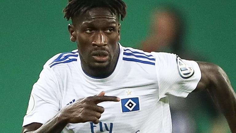 Bakéry Jatta trägt ein weißes Trikot und läuft. Bakéry Jatta trägt ein weißes Trikot und läuft.