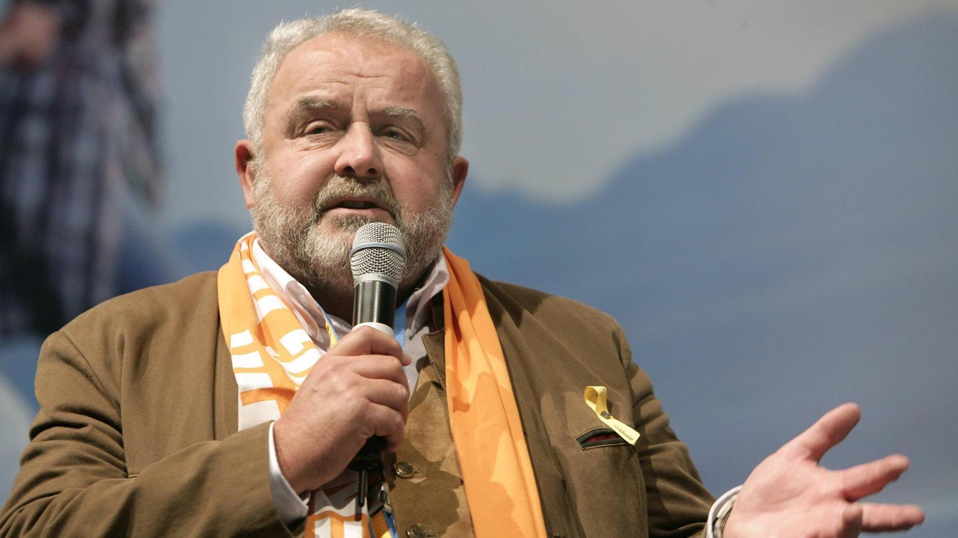 Reinhard Erös spricht bei einer Podiumsdiskussion in ein Mikrofon Reinhard Erös spricht bei einer Podiumsdiskussion in ein Mikrofon
