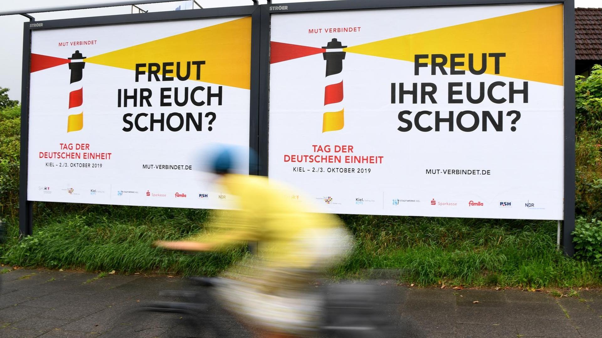 Ein Radfahrer fährt an Plakaten mit der Aufschrift "Freut Ihr Euch schon" entlang. Ein Radfahrer fährt an Plakaten mit der Aufschrift "Freut Ihr Euch schon" entlang.