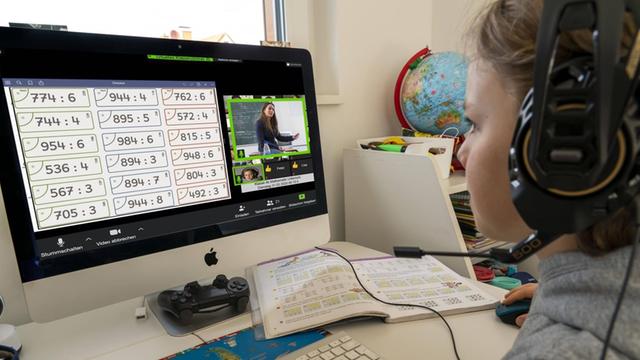 Ein Junge mit Kopfhörern sitzt beim Homeschooling vor einem Bildschirm.