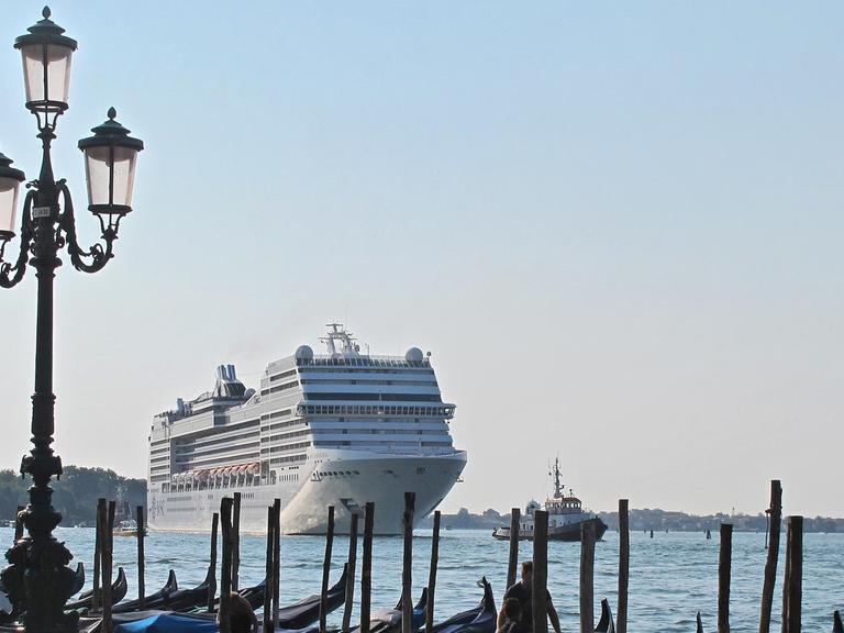 Das für mehr als 2500 Passagiere ausgelegte Kreuzfahrtschiff MSC Magnifica befährt am 09.08.2015 den Canale di S. Marco in Richtung Stadthafen. Im Vordergrund Gondeln an der Riva degli Schiavoni.