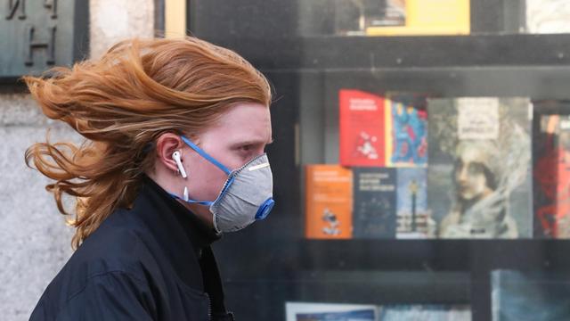 Eine Frau mit einer Gesichtsmaske geht an der Moskauer Buchhandlung in der Twerskaja-Straße vorbei. Der Laden ist wegen der Coronavirus-Pandemie COVID-19 geschlossen. Mehr als 500 Schriftsteller und Verleger haben die russische Regierung aufgefordert, die Buchbranche zu unterstützen und Bücher in die Liste des Bedarfs aufzunehmen.