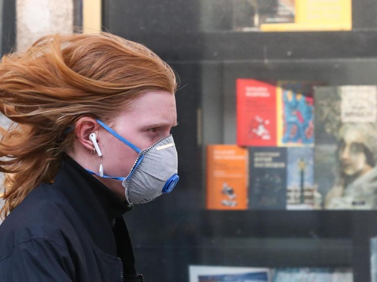 Eine Frau mit einer Gesichtsmaske geht an der Moskauer Buchhandlung in der Twerskaja-Straße vorbei. Der Laden ist wegen der Coronavirus-Pandemie COVID-19 geschlossen. Mehr als 500 Schriftsteller und Verleger haben die russische Regierung aufgefordert, die Buchbranche zu unterstützen und Bücher in die Liste des Bedarfs aufzunehmen.