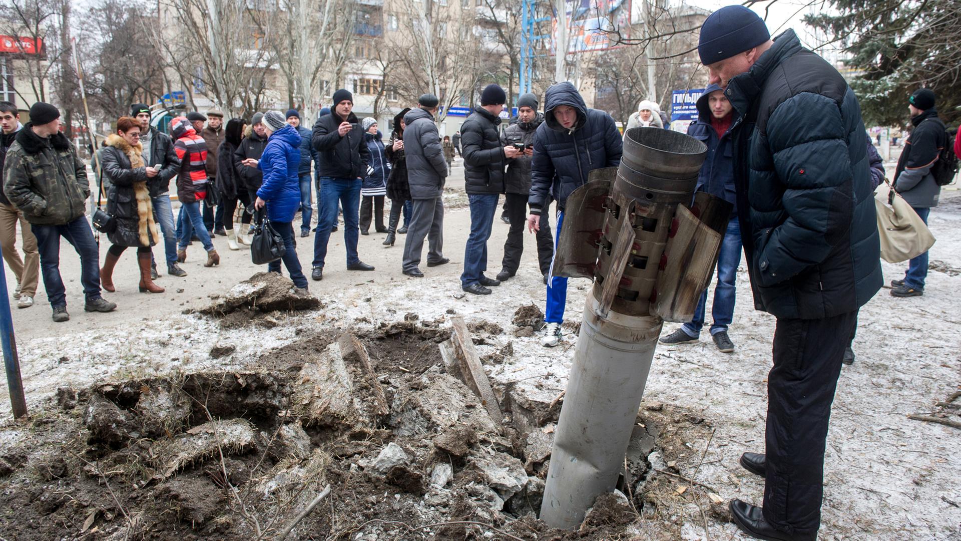 Nach dem Einschlag einer Rakete in der Stadt Kramatorsk versammeln sich viele Zivilisten um den Krater. Nach dem Einschlag einer Rakete in der Stadt Kramatorsk versammeln sich viele Zivilisten um den Krater.