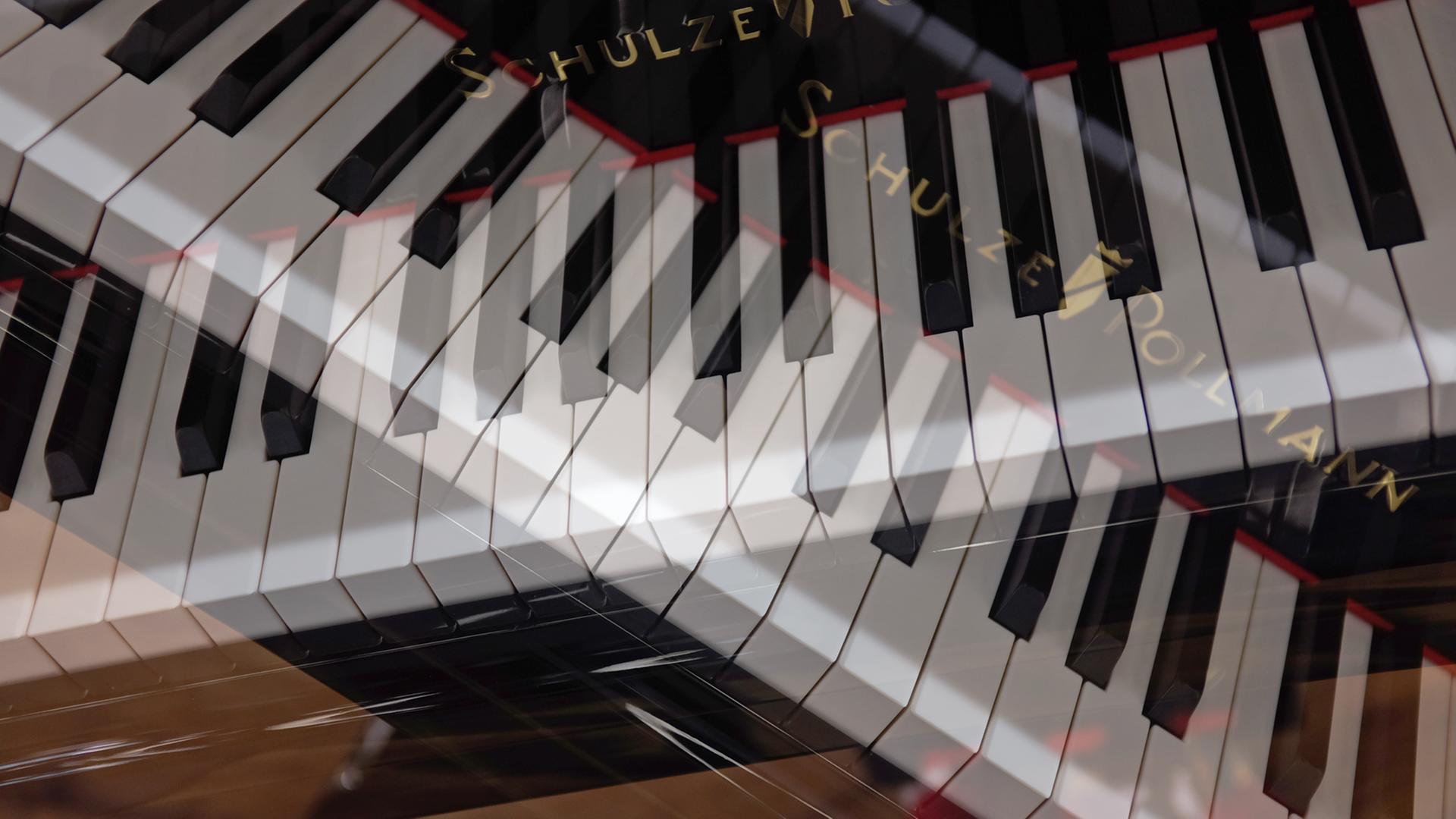 Ein mehrfach belichtetes Foto zeigt zwei gekreuzte Piano-Klaviaturen. Ein mehrfach belichtetes Foto zeigt zwei gekreuzte Piano-Klaviaturen.