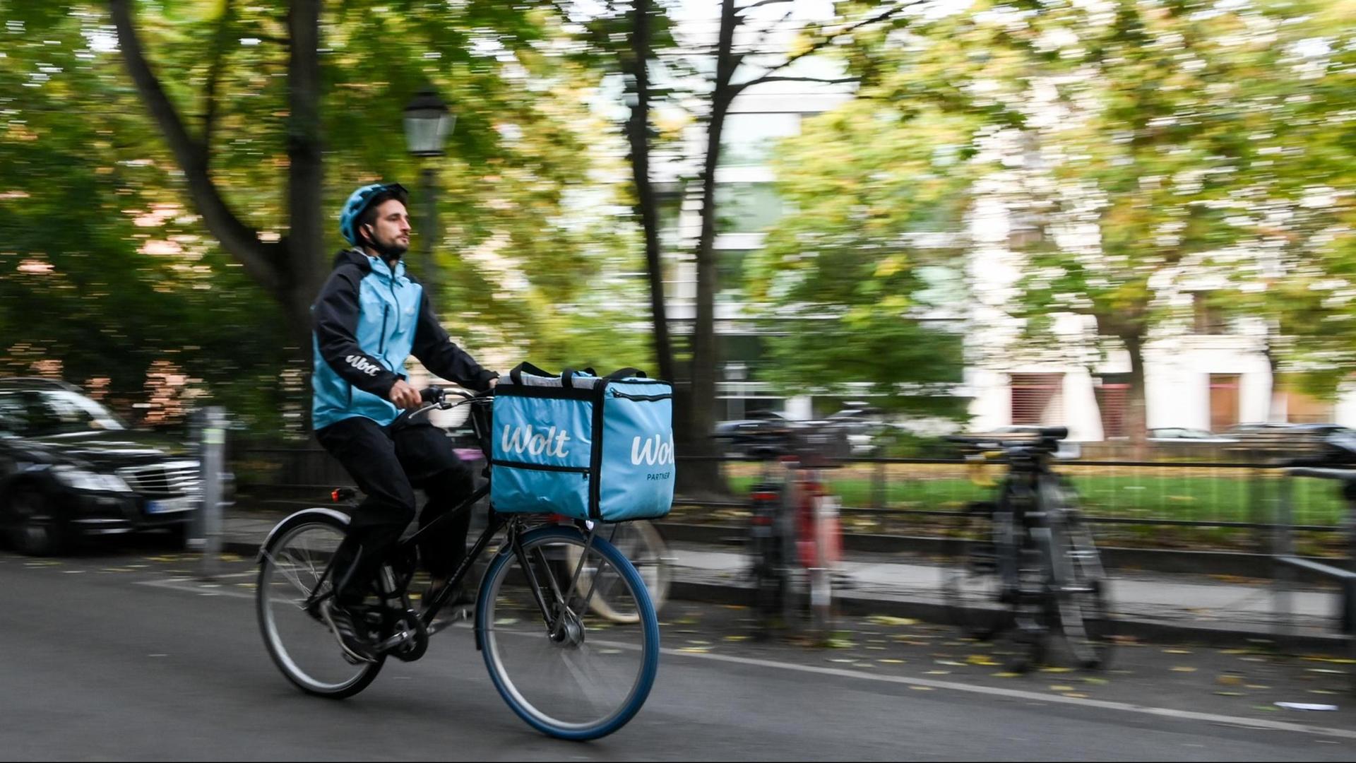 Ein Fahrradkurier ist für den Essenslieferdienst Wolt in einer Straße in Berlin-Mitte unterwegs. Ein Fahrradkurier ist für den Essenslieferdienst Wolt in einer Straße in Berlin-Mitte unterwegs.