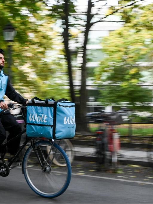 Ein Fahrradkurier ist für den Essenslieferdienst Wolt in einer Straße in Berlin-Mitte unterwegs.