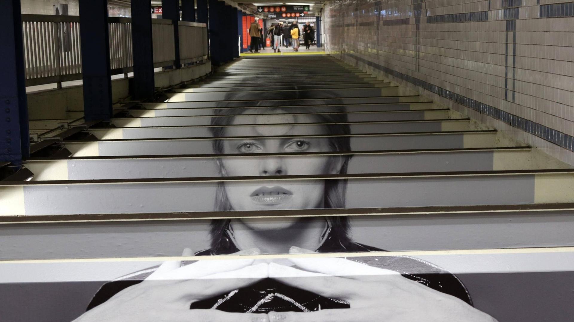 Über die Treppenstufen in der New Yorker U-Bahn ist ein Abbild von David Bowie gedruckt. Über die Treppenstufen in der New Yorker U-Bahn ist ein Abbild von David Bowie gedruckt.