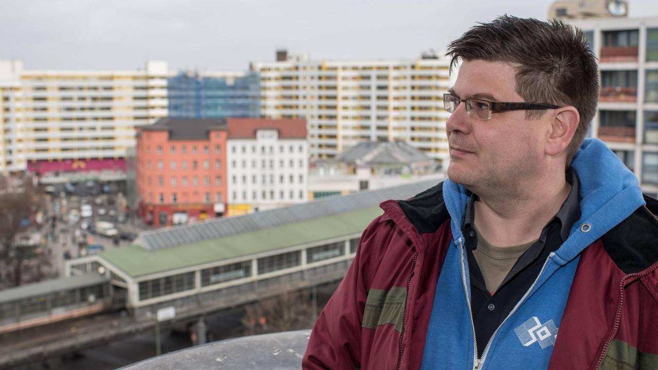 Andrej Holm steht auf einer Terrasse in Kreuzberg mit dem Wohnkomplex Zentrum Kreuzberg in seinem Rücken. Andrej Holm steht auf einer Terrasse in Kreuzberg mit dem Wohnkomplex Zentrum Kreuzberg in seinem Rücken.
