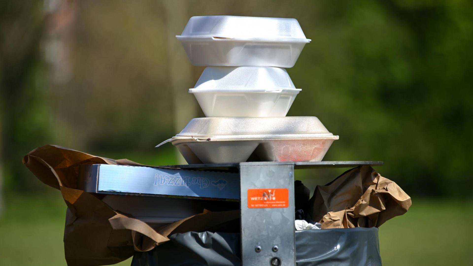 Leere Speise-Verpackungen stapeln sich im Nordstadtpark in Kassel auf einem Mülleimer. Leere Speise-Verpackungen stapeln sich im Nordstadtpark in Kassel auf einem Mülleimer.