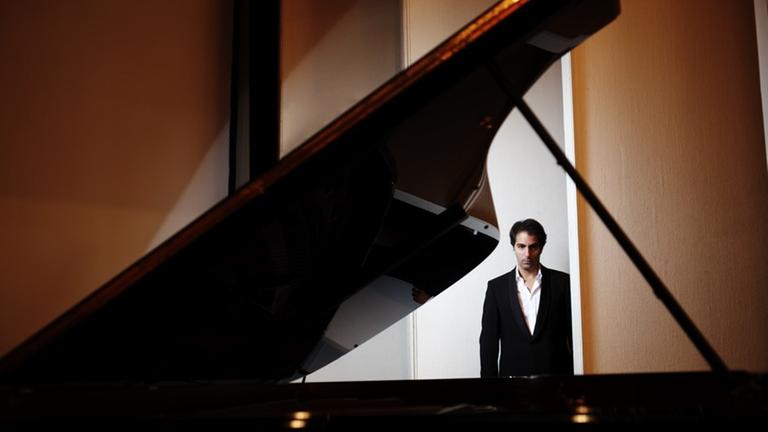 Der Pianist ist durch einen aufgeklappten Flügel hindurch zu sehen. Der Pianist ist durch einen aufgeklappten Flügel hindurch zu sehen.