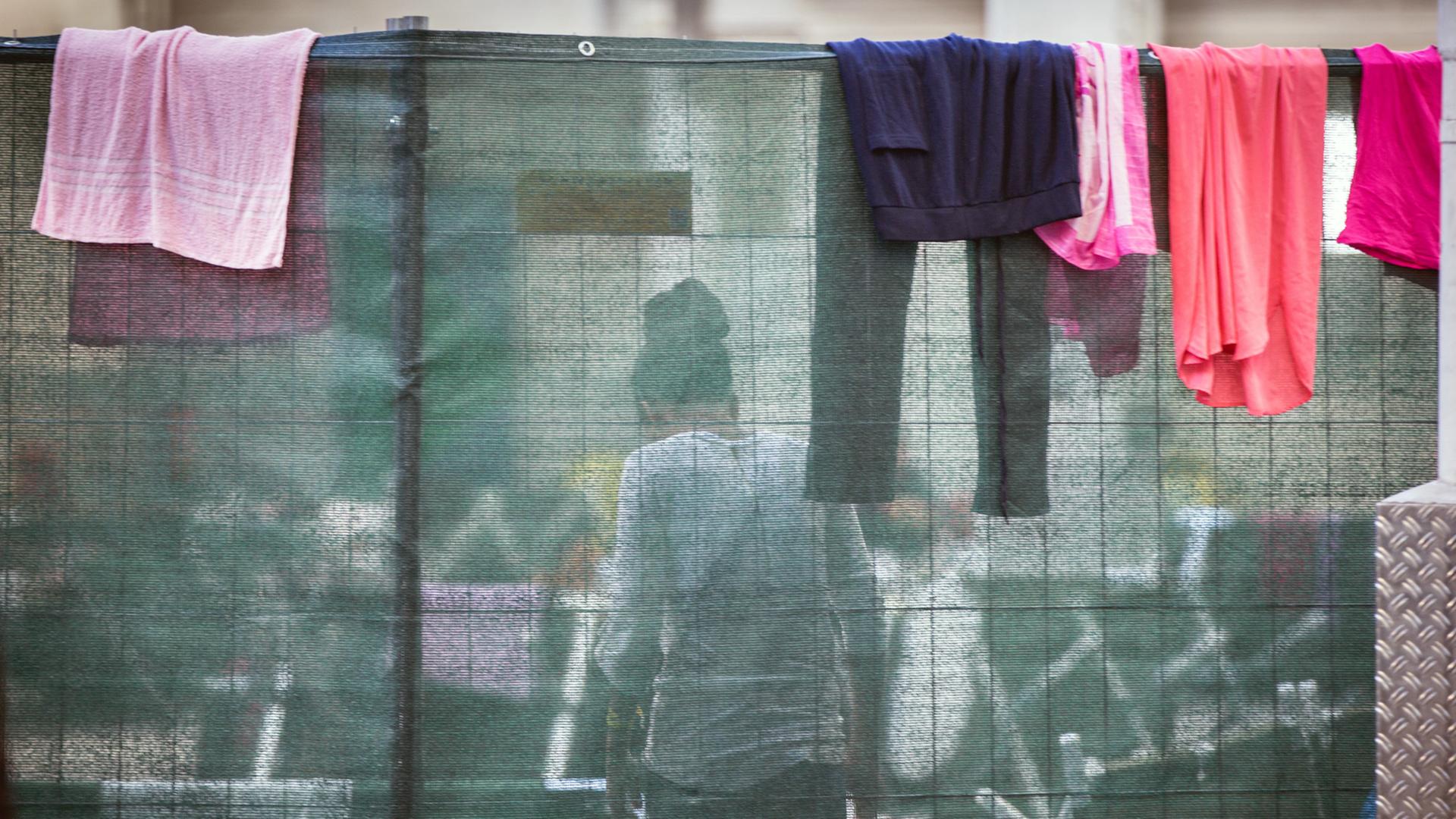 Wäsche auf einer Trennwand in einer Flüchtlingsunterkunft Wäsche auf einer Trennwand in einer Flüchtlingsunterkunft