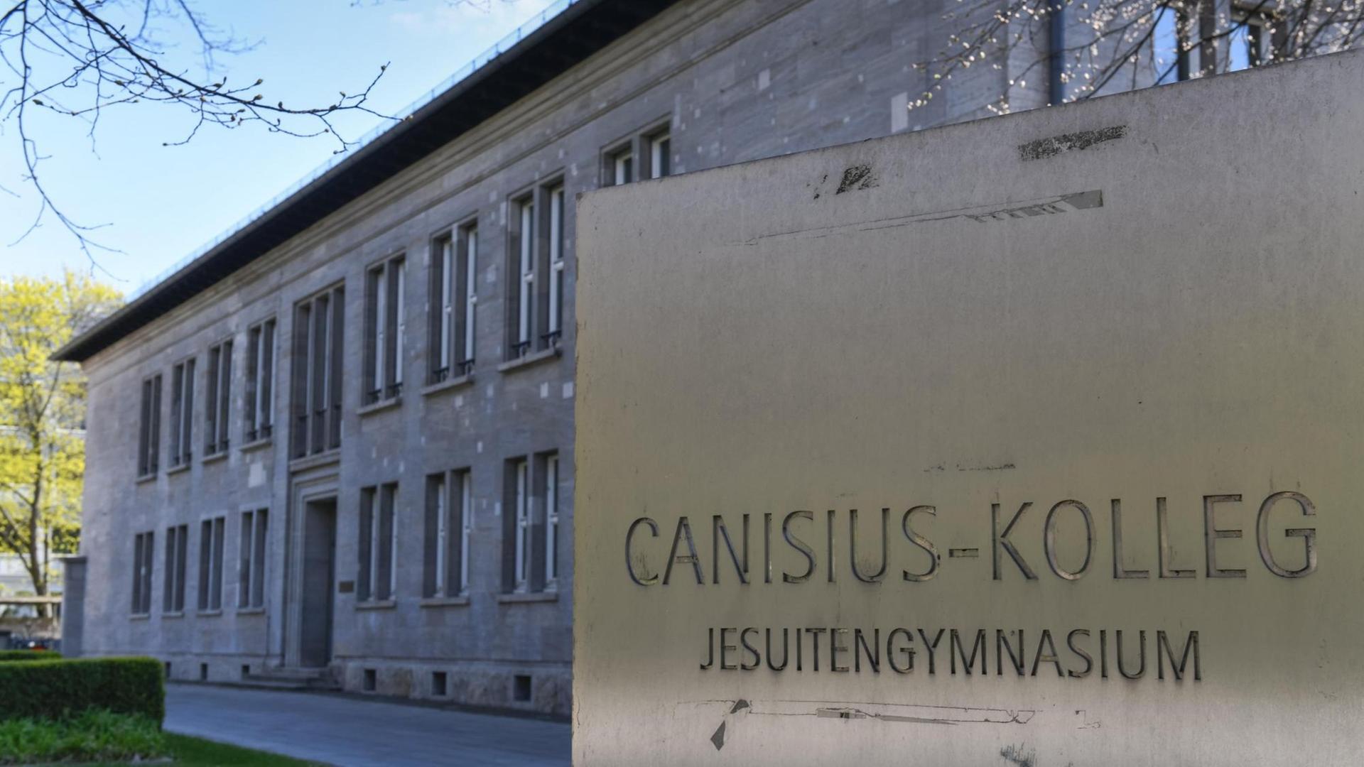 Das Canisius-Kolleg in Berlin-Tiergarten. Ein graues Schulgebäude, davor ist eine Tafel mit dem Namen der Schule. Das Canisius-Kolleg in Berlin-Tiergarten. Ein graues Schulgebäude, davor ist eine Tafel mit dem Namen der Schule.