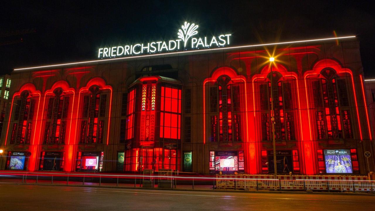 Der abendliche Friedrichstadt-Palast in Berlin, rot angestrahlt.