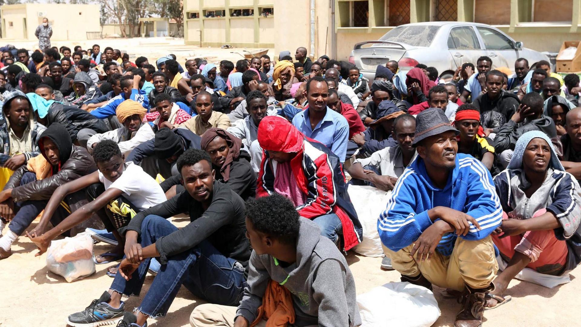 Flüchtlinge sitzen in Libyen in einem Zentrum für illegale Flüchtlinge fest. Flüchtlinge sitzen in Libyen in einem Zentrum für illegale Flüchtlinge fest.