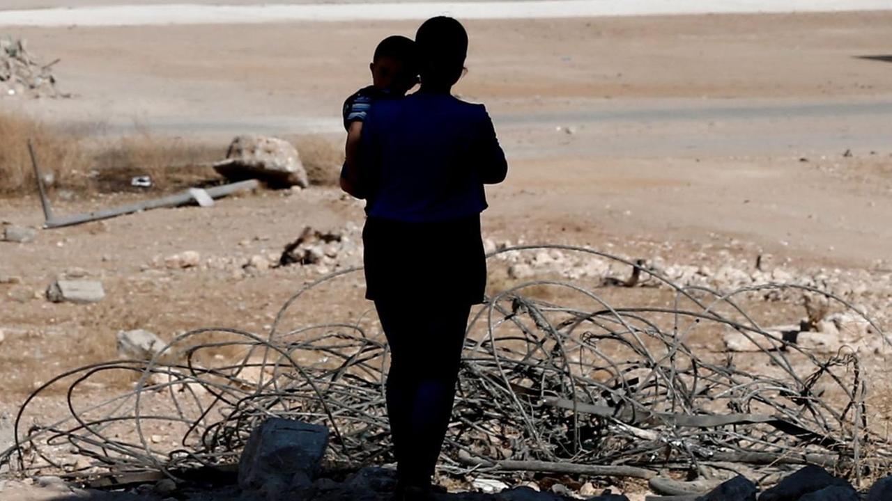Eine Frau mit ihrem Kind im zerstörten Kobane (Syrien). Eine Frau mit ihrem Kind im zerstörten Kobane (Syrien).