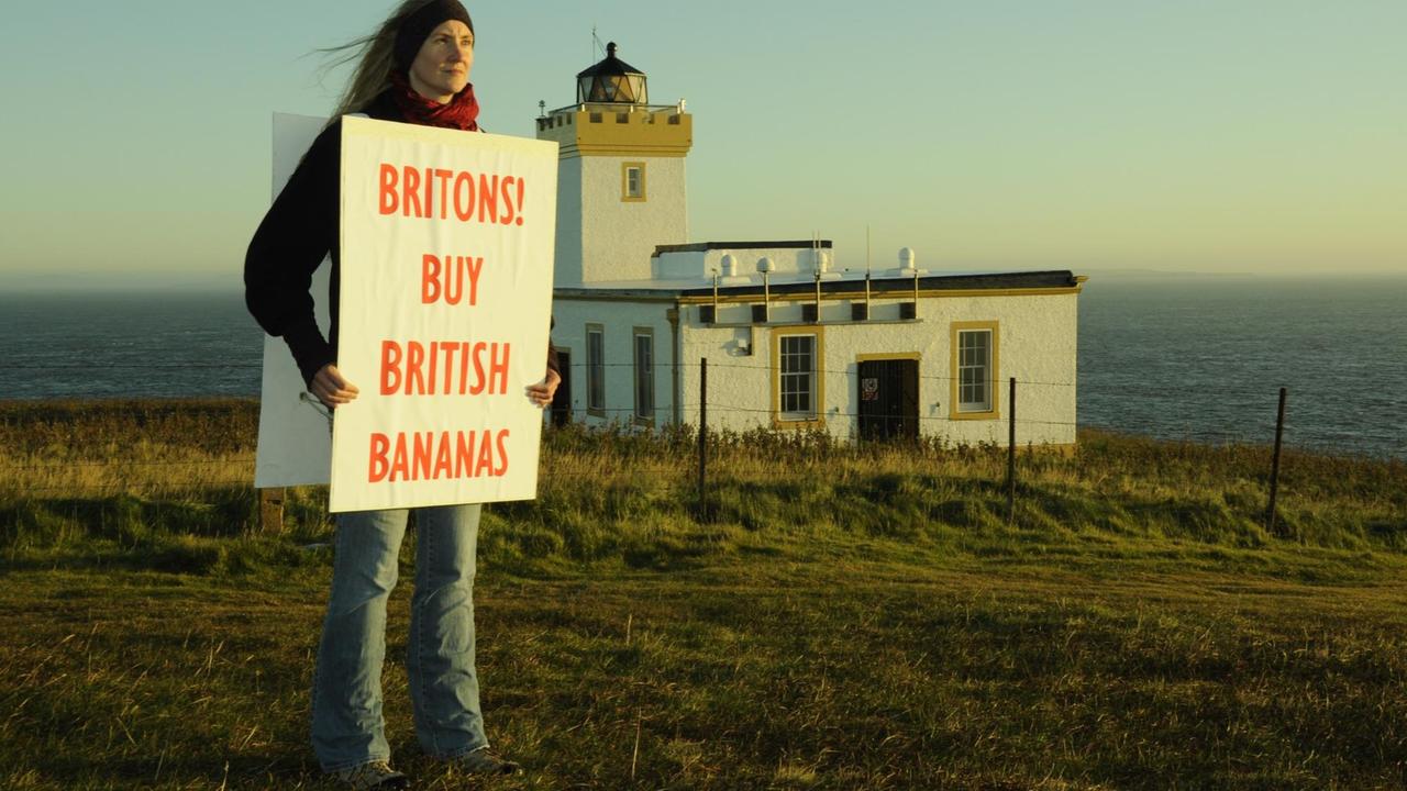Die aus Deutschland stammende Künstlerin Bibo Keeley bei ihrer Brexit-Kunstperformance in Duncansby Head. Sie hält ein Schild mit der Aufschrift "Britons - Buy British Bananas" in den Händen. Die aus Deutschland stammende Künstlerin Bibo Keeley bei ihrer Brexit-Kunstperformance in Duncansby Head. Sie hält ein Schild mit der Aufschrift "Britons - Buy British Bananas" in den Händen.