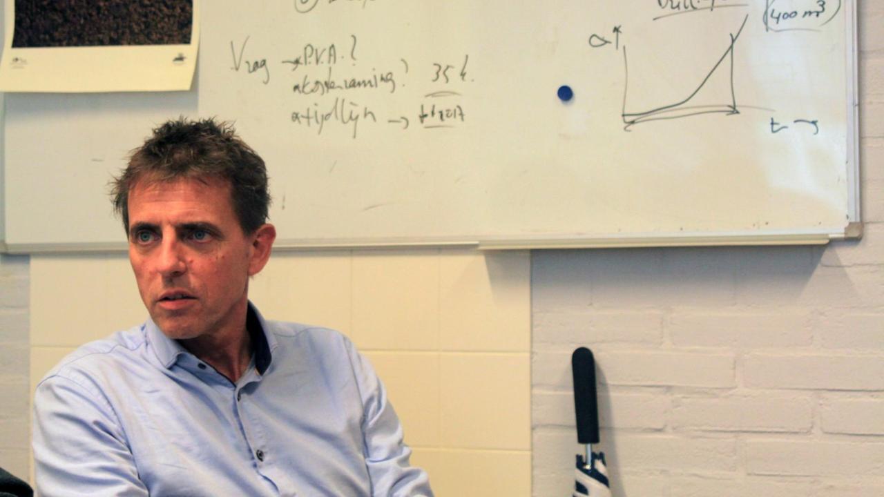 Henk Jonkers sitzt vor einer beschrifteten Tafel in einem Seminarraum Henk Jonkers sitzt vor einer beschrifteten Tafel in einem Seminarraum