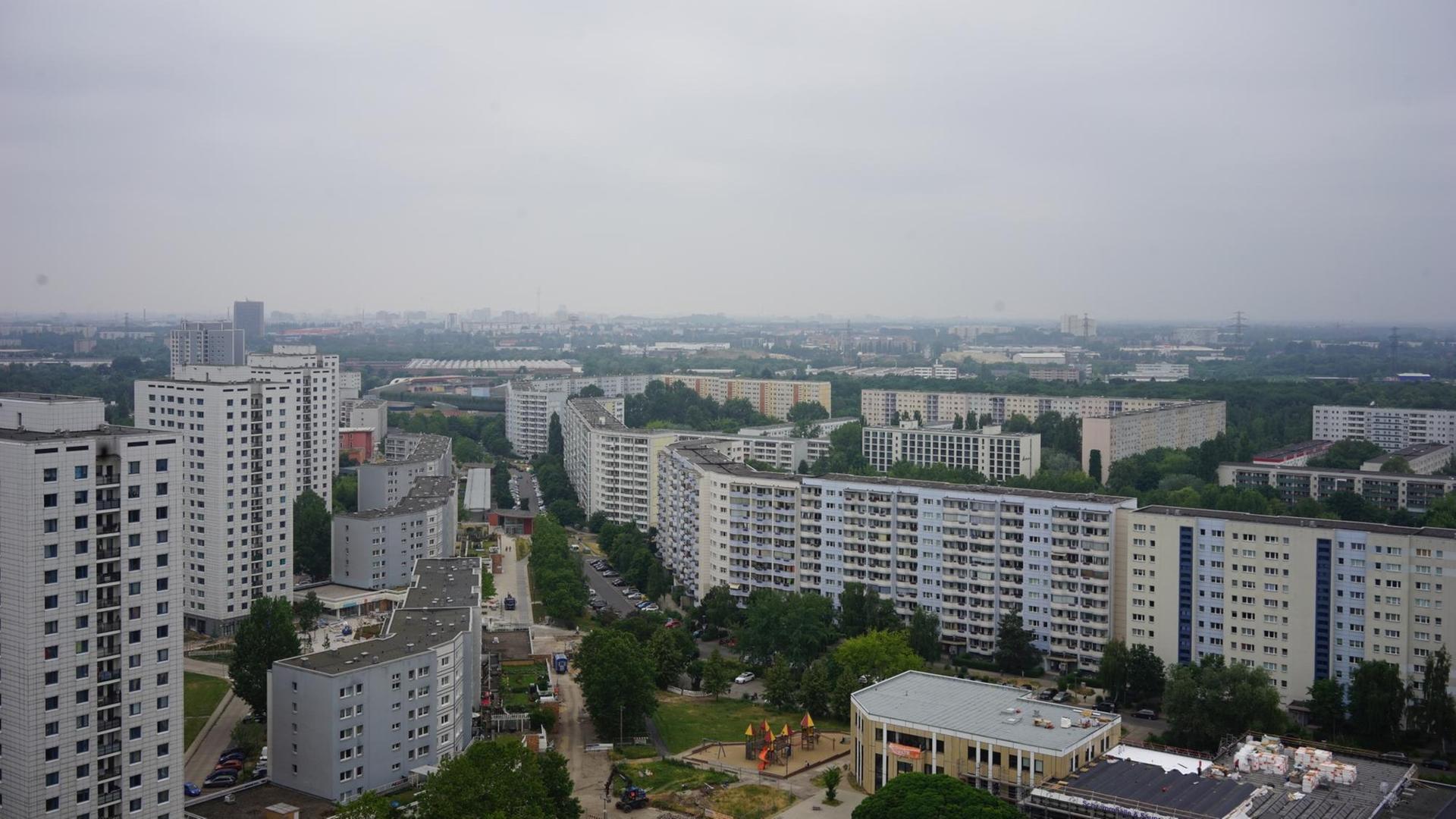 Ein Blick von einer erhöhten Perspektive auf die zahlreichen Hochhaussiedlungen des Berliner Bezirks Marzahn. Zwischen den Gebäuden sind zahlreiche Bäume zu sehen. Der Himmel ist grau. Ein Blick von einer erhöhten Perspektive auf die zahlreichen Hochhaussiedlungen des Berliner Bezirks Marzahn. Zwischen den Gebäuden sind zahlreiche Bäume zu sehen. Der Himmel ist grau.
