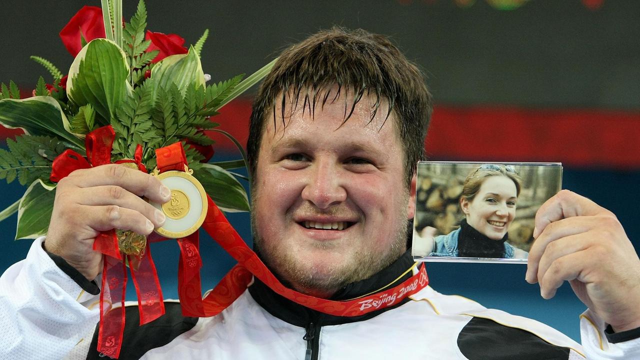 Matthias Steiner aus Deutschland feiert den Gewinn der Goldmedaille im Gruppengewichtheben der Männer über 105 kg, während er ein Foto seiner verstorbenen Frau Suzanne Steiner in der Sporthalle der Universität für Luft- und Raumfahrt Peking am Tag 11 der Olympischen Spiele 2008 in Peking am 19. August 2008 in Peking, China, hält. Matthias Steiner aus Deutschland feiert den Gewinn der Goldmedaille im Gruppengewichtheben der Männer über 105 kg, während er ein Foto seiner verstorbenen Frau Suzanne Steiner in der Sporthalle der Universität für Luft- und Raumfahrt Peking am Tag 11 der Olympischen Spiele 2008 in Peking am 19. August 2008 in Peking, China, hält.