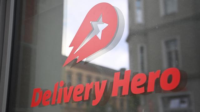 Das Logo Essenlieferdienstes Delivery Hero ist an einer Glasscheibe der Zentrale angebracht. (Aufnahme mit Zoomeffekt). Der internationale Essenlieferdienst Delivery Hero steigt in den Deutschen Aktienindex (Dax) auf.