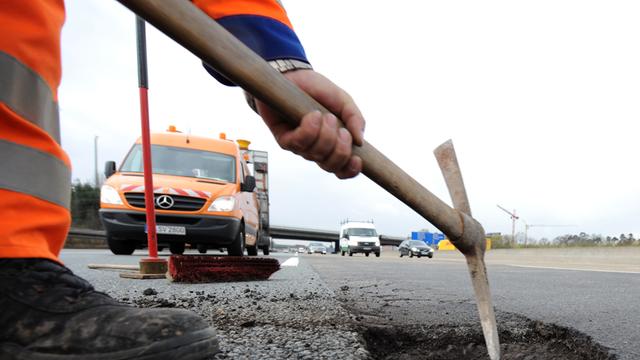 Ein Asphaltschaden wird auf der Autobahn A5 unweit des Frankfurter Kreuzes von der Straßen- und Autobahnmeisterei Frankfurt repariert