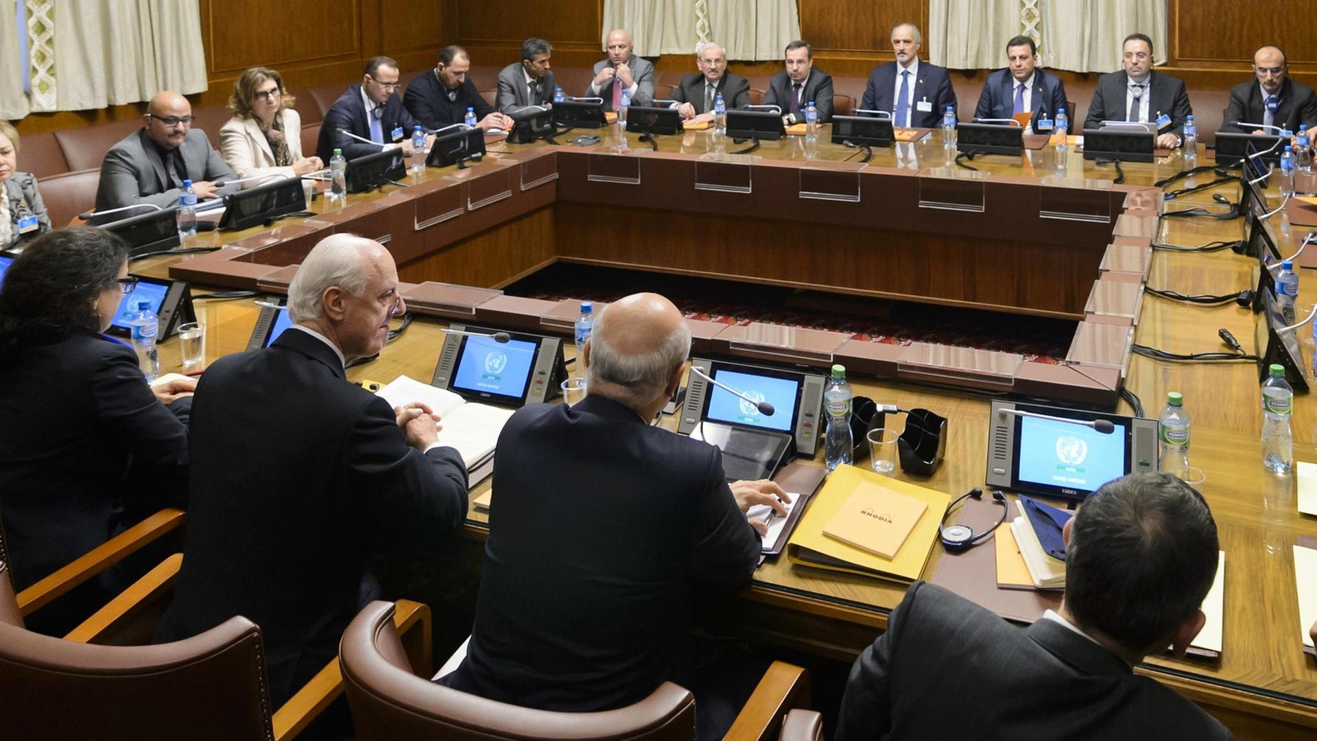 Die Teilnehmer der Syrien-Friedensgespräche sitzen an einem viereckigen Tisch in einem Gebäude der Vereinten Nationen in Genf zusammen. at the opening of Syrian peace talks with the Syrian government delegation at the United Nations (UN) Offices in Geneva Die Teilnehmer der Syrien-Friedensgespräche sitzen an einem viereckigen Tisch in einem Gebäude der Vereinten Nationen in Genf zusammen. at the opening of Syrian peace talks with the Syrian government delegation at the United Nations (UN) Offices in Geneva