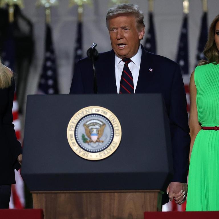 Präsident Trump an einem Rednerpult, mit seiner Frau Melania rechts und seiner Tochter Ivanka links von ihm.