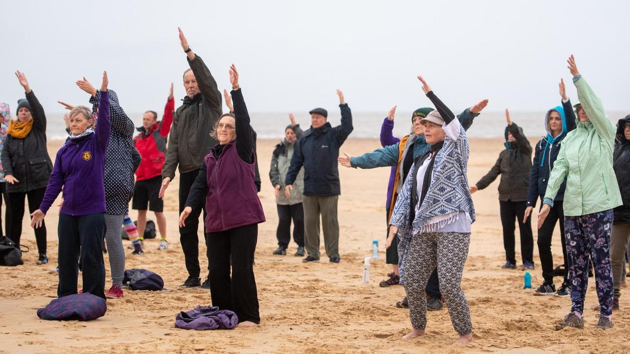 Ältere Menschen bei Meditations-, Konzentrations- und Bewegungsübungen am Strand. Ältere Menschen bei Meditations-, Konzentrations- und Bewegungsübungen am Strand.