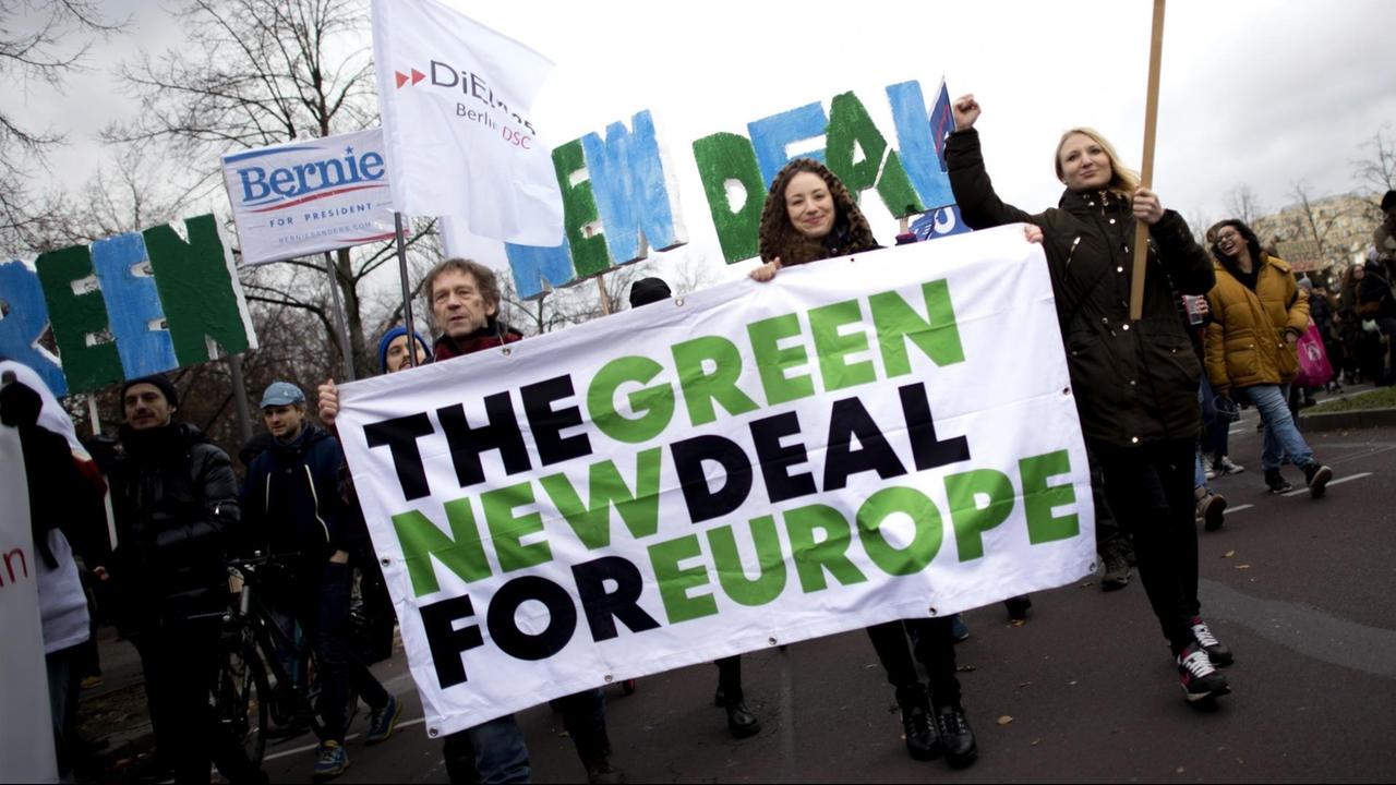 Demonstrierende mit einem Transparent "The Green New Deal For Europe"