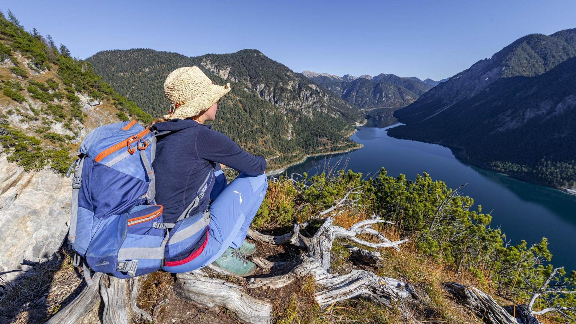 Eine Wanderin rastet und schaut in die Ferne. Eine Wanderin rastet und schaut in die Ferne.