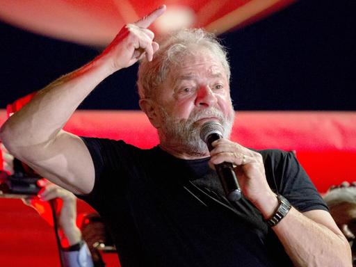 Lula da Silva hält ein Mikrofon und streckt einen Finger in die Höhe.