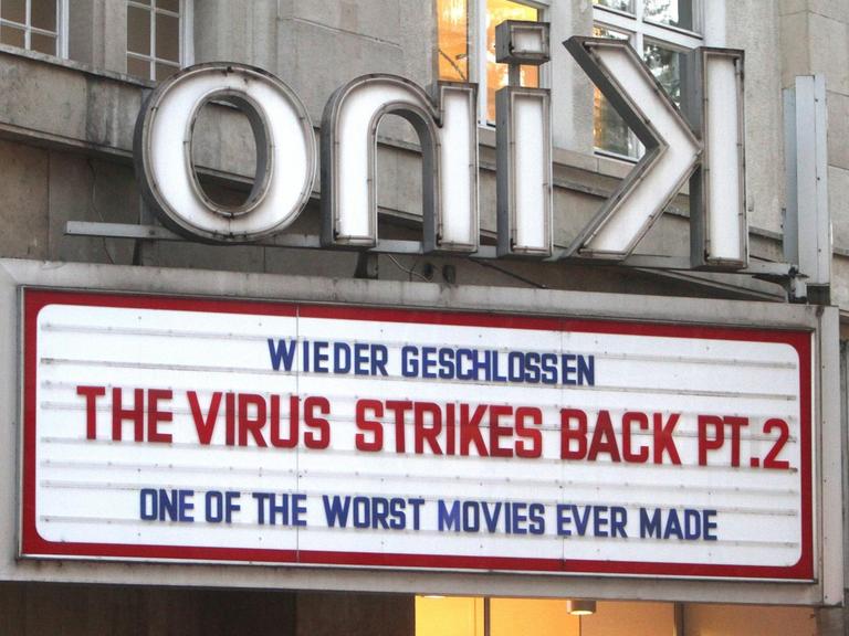 "Wieder geschlossen - Das Virus schlägt zurück Teil 2 - Einer der schlechtesten Filme, die je gedreht wurden" steht auf Englisch über dem Eingang eines Kinos.
