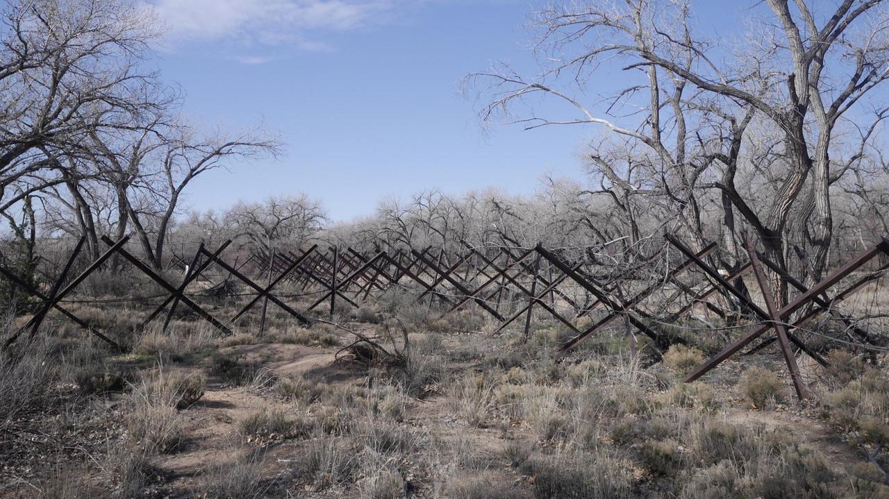 Verstrebungen aus Stahl, die ursprünglich als Panzersperren dienten, stehen im Gebüsch am Ufer des Rio Grande Verstrebungen aus Stahl, die ursprünglich als Panzersperren dienten, stehen im Gebüsch am Ufer des Rio Grande