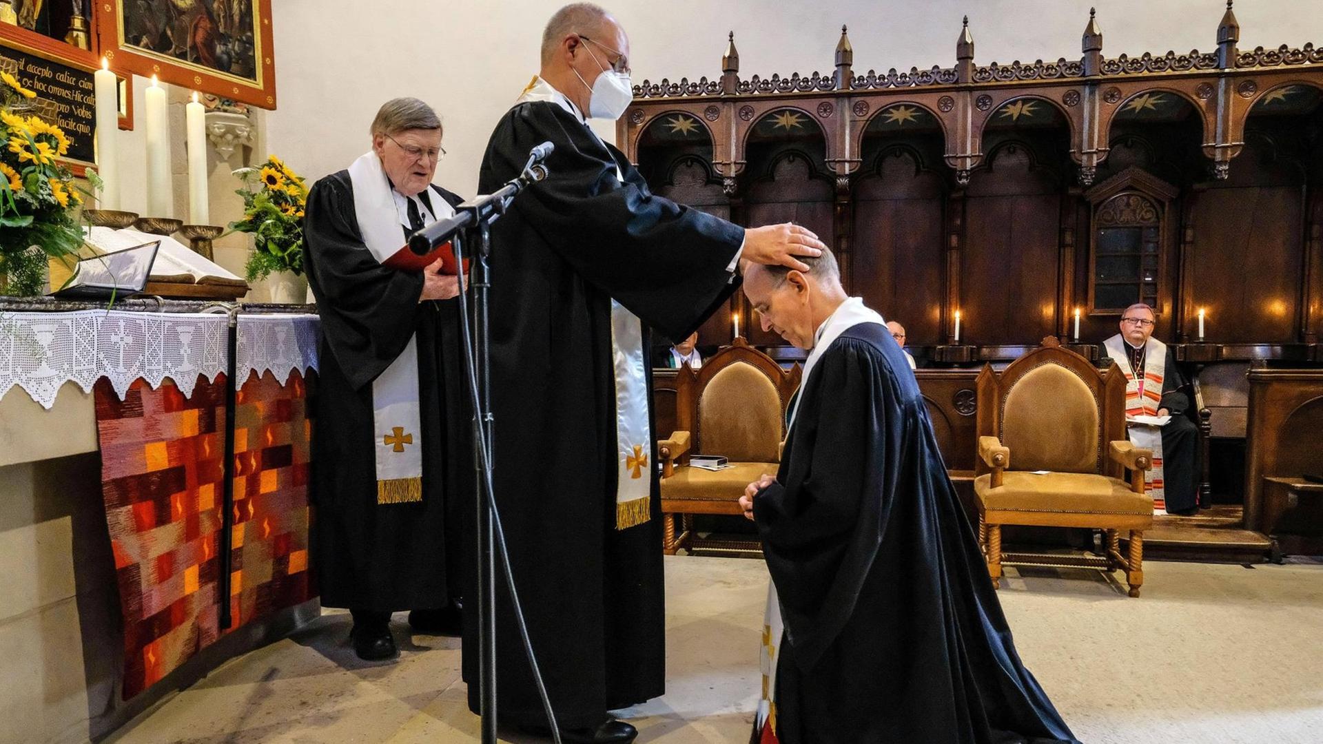 Ralf Meister wird durch Prior Arend de Vries in das Amt des Abtes des Klosters Loccum eingefuehrt, im Hintergrund steht Horst Hirschler. Der 58-jaehrige Theologe tritt die Nachfolge von Horst Hirschler 87 an, der das Amt 20 Jahre lang innehatte.