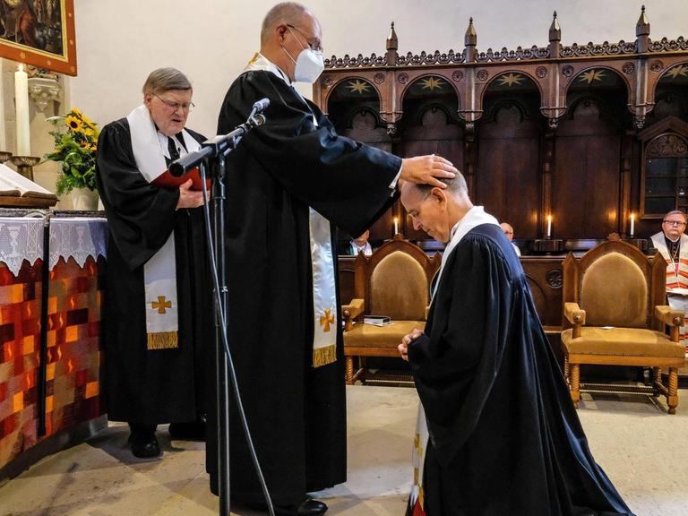 Ralf Meister wird durch Prior Arend de Vries in das Amt des Abtes des Klosters Loccum eingefuehrt, im Hintergrund steht Horst Hirschler. Der 58-jaehrige Theologe tritt die Nachfolge von Horst Hirschler 87 an, der das Amt 20 Jahre lang innehatte.