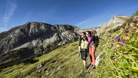 Ein junges Paar wandert in den Alpen bei Altenmarkt-Zauchensee in Österreich.