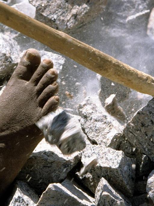Barfüßig arbeitet ein Mitglied der Kaste der Unberührbaren in einem Steinbruch in Madurai (Indien).