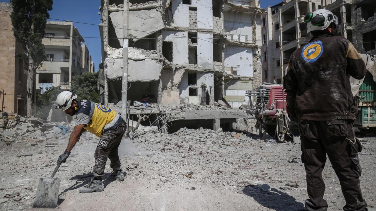 "Weißhelme" räumen Schutt vor einem von einem Luftangriff zerstörten Gebäude in Idlib (Syrien). "Weißhelme" räumen Schutt vor einem von einem Luftangriff zerstörten Gebäude in Idlib (Syrien).