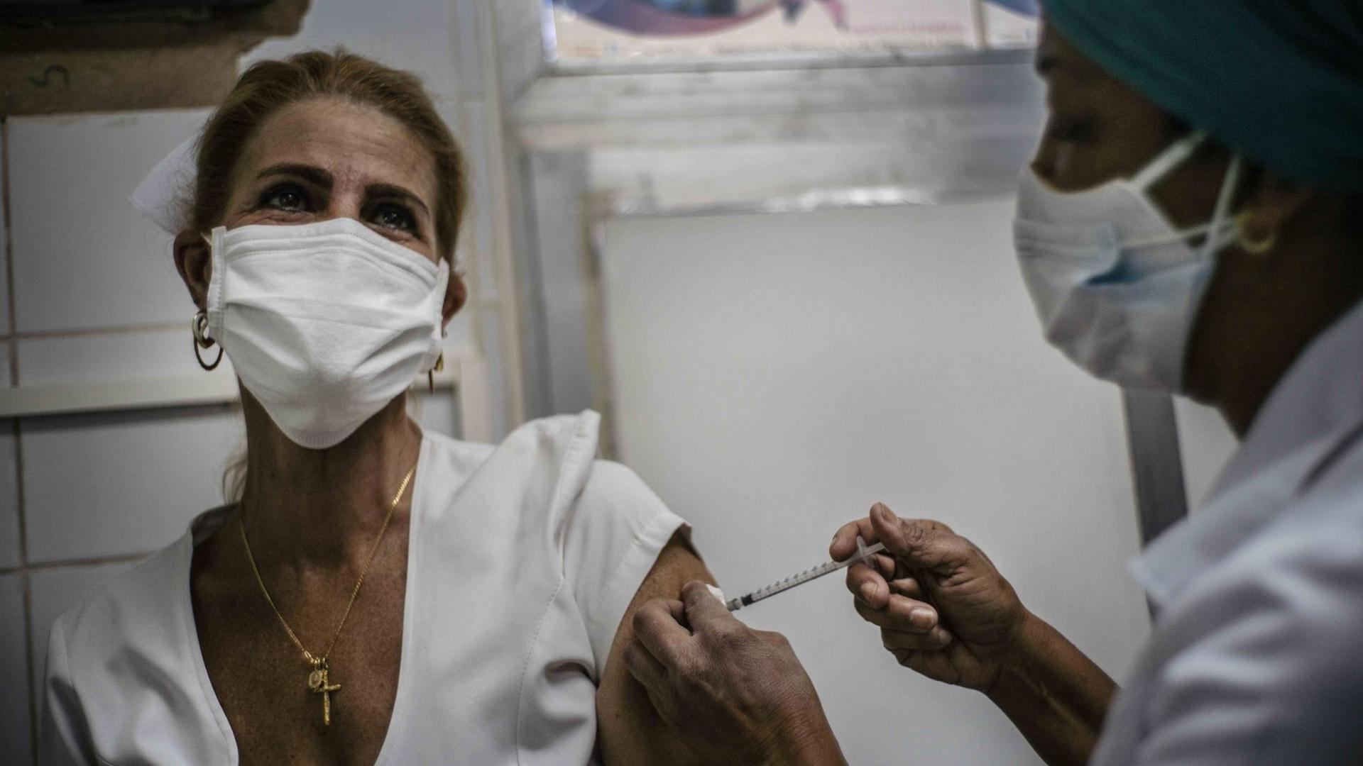 Eine Krankenschwester impft eine Mitarbeiterin des medizinischen Personals am 24. März in Havanna mit dem Impfstoff "Soberana-02" gegen COVID-19. Eine Krankenschwester impft eine Mitarbeiterin des medizinischen Personals am 24. März in Havanna mit dem Impfstoff "Soberana-02" gegen COVID-19.