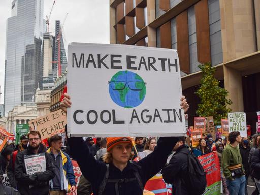 Ein Demonstrant hält ein Banner mit der Aufschrift "Make Earth Cool Again" bei einer Demonstration am 6. November in London.