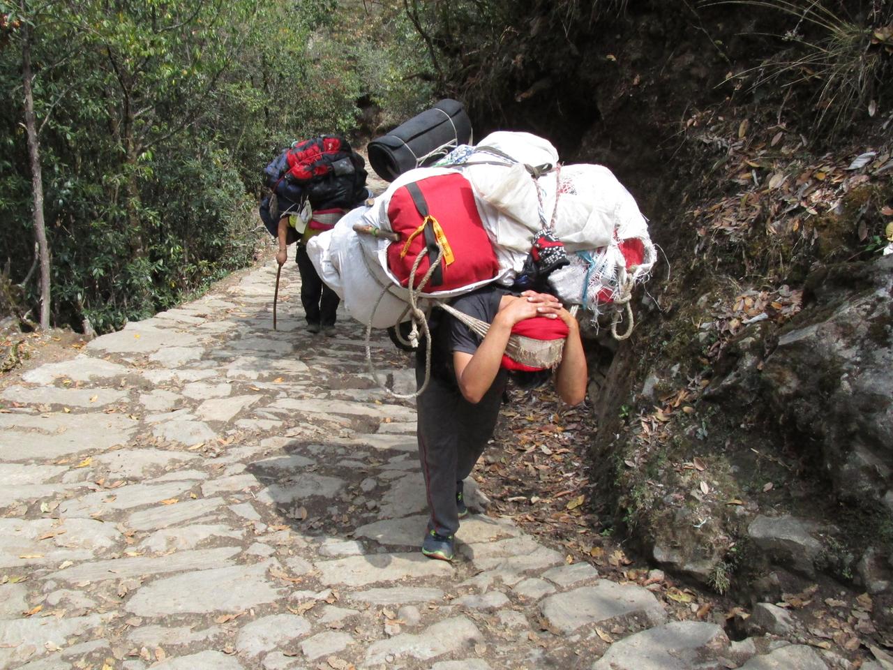 Träger auf dem Weg nach Namche Bazar, dem Hauptort der Sherpas am Mount Everest Massiv Träger auf dem Weg nach Namche Bazar, dem Hauptort der Sherpas am Mount Everest Massiv