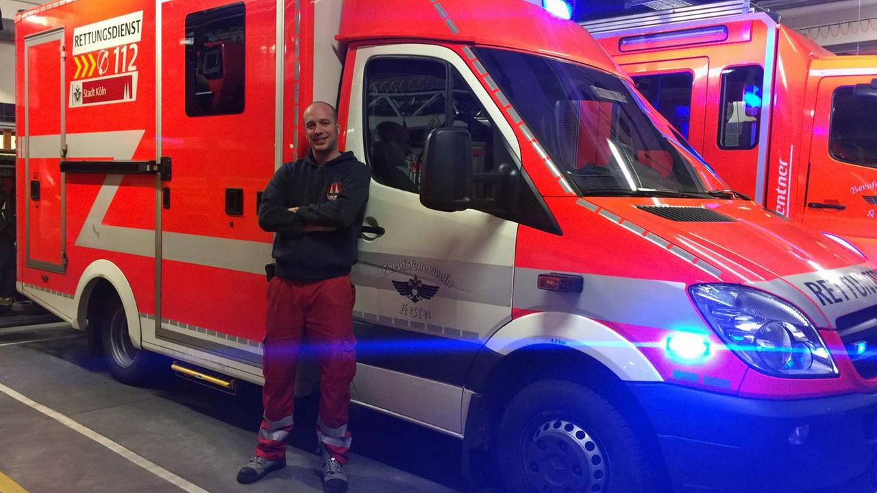 Sebastian Ackermann steht vor einem Rettungswagen.