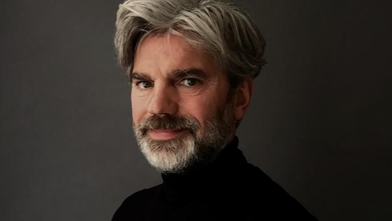 Der Fotograf Florian Jaenicke im Halbporträt vor einem dunklen Hintergrund. Der Fotograf Florian Jaenicke im Halbporträt vor einem dunklen Hintergrund.