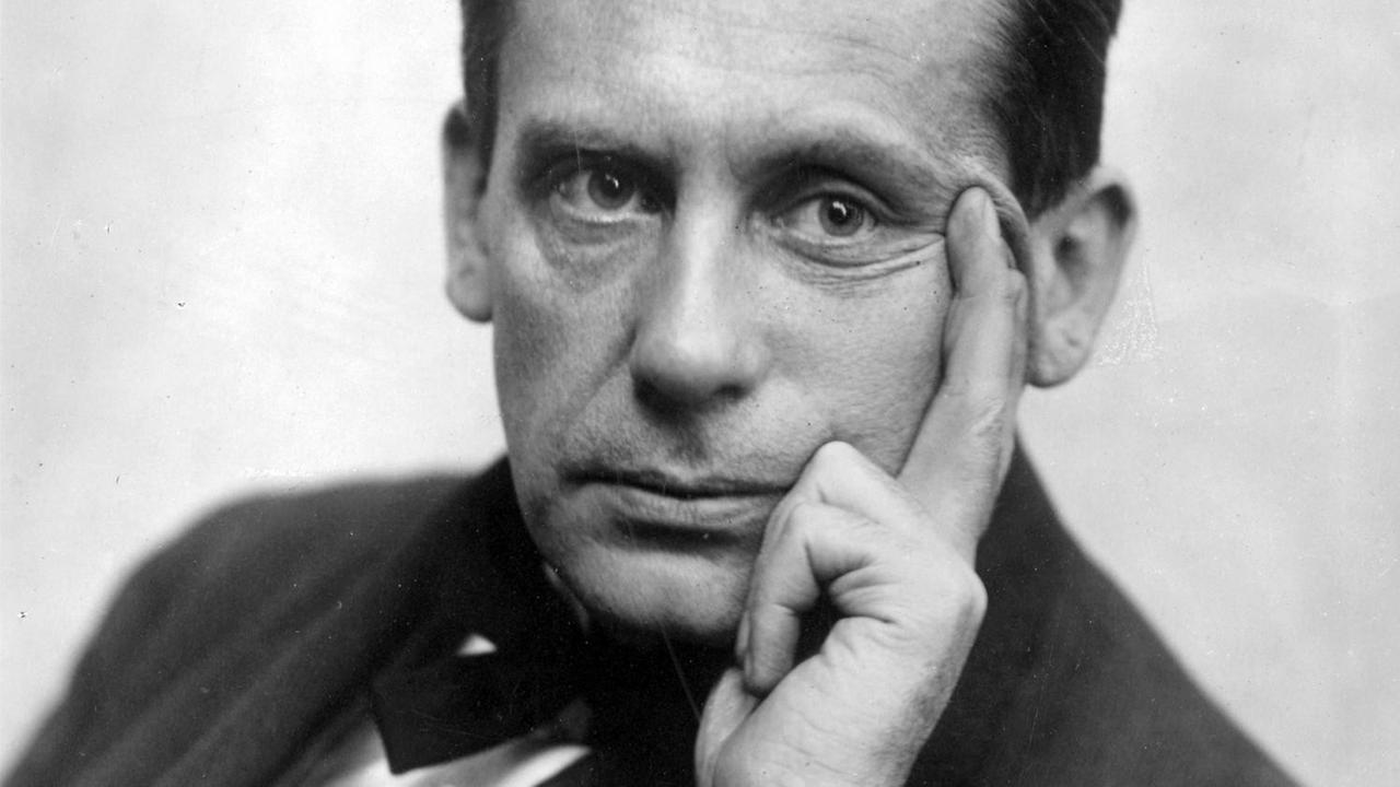 Walter Gropius stützt sein Gesicht auf seine Hand und schaut in die Kamera. Walter Gropius stützt sein Gesicht auf seine Hand und schaut in die Kamera.