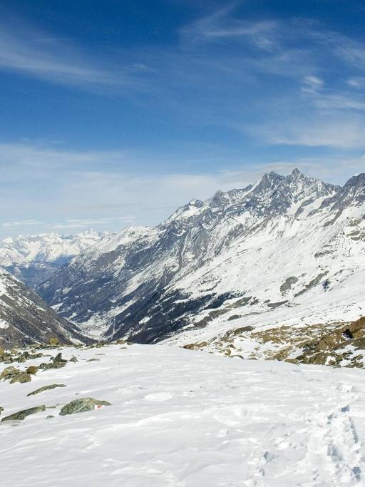Eine Schweizer Fahne steckt im Schnee vor einem Alpenpanorama. Foto: imago stock&people