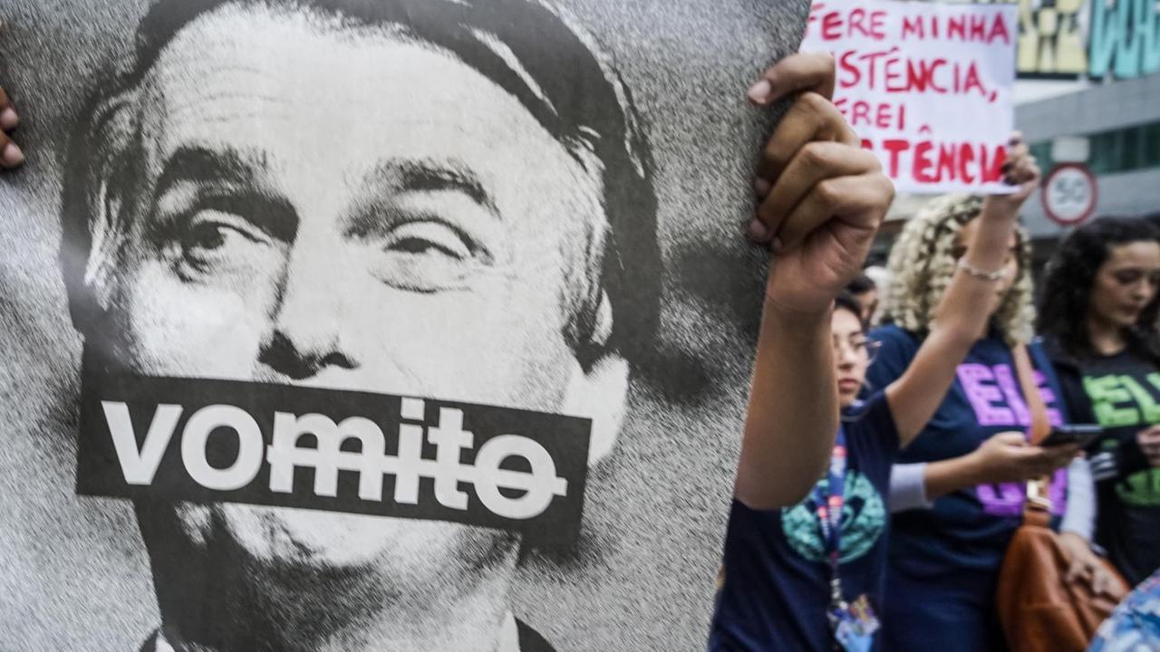 Eine Frau hält bei einer Demonstration gegen den rechtsextremen Präsidentschaftskandidaten Bolsonaro ein Bild von Bolsonaro mit der Aufschrift "Vomito" ("Erbrochene") hoch. Zahlreiche Menschen gingen in Sao Paulo gegen Bolsonaro und seinen rassistischen, frauen- und schwulenfeindlichen Kurs auf die Straße. Eine Frau hält bei einer Demonstration gegen den rechtsextremen Präsidentschaftskandidaten Bolsonaro ein Bild von Bolsonaro mit der Aufschrift "Vomito" ("Erbrochene") hoch. Zahlreiche Menschen gingen in Sao Paulo gegen Bolsonaro und seinen rassistischen, frauen- und schwulenfeindlichen Kurs auf die Straße.
